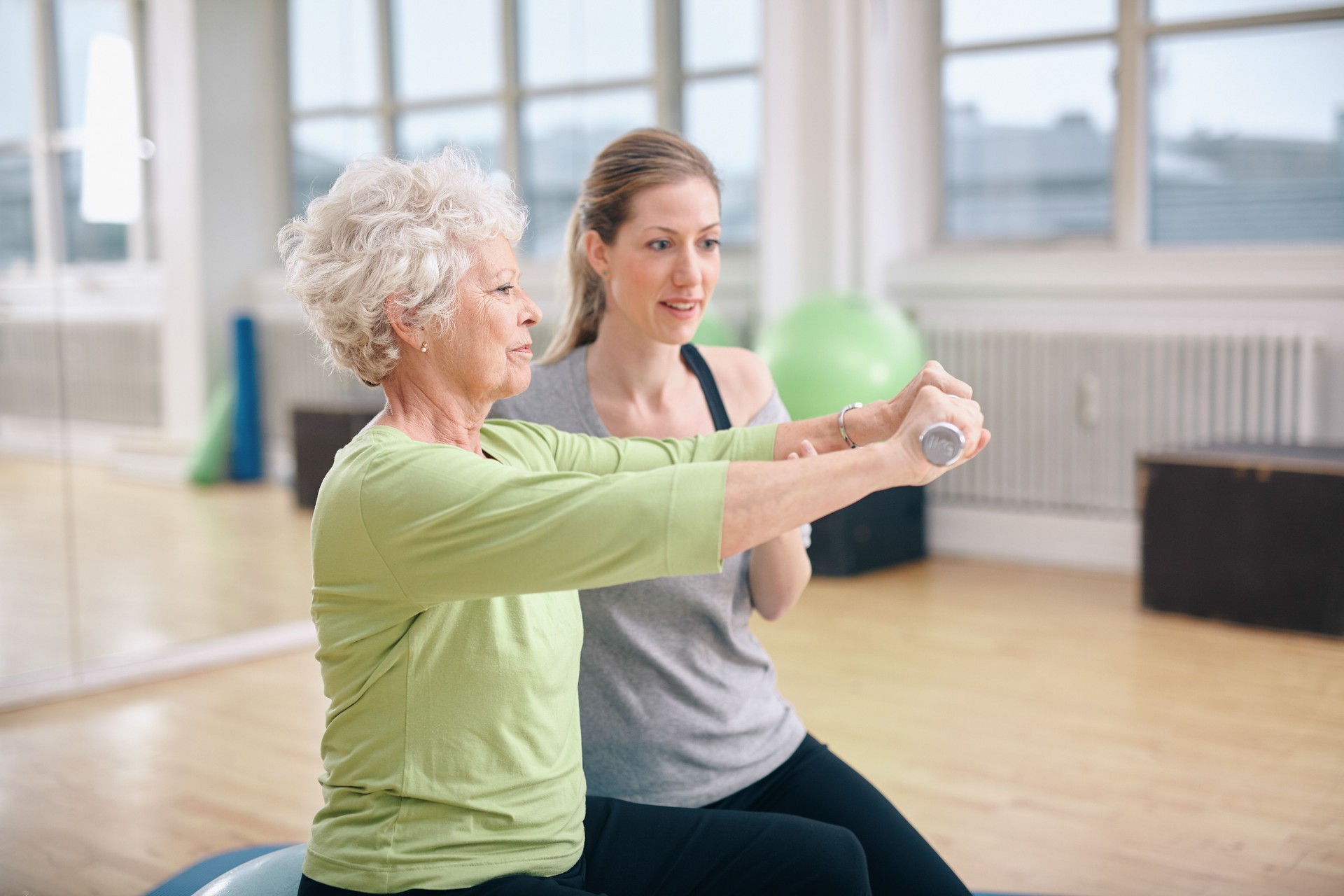 Senior woman training in the gym with a personal trainer